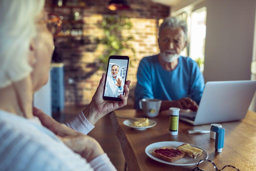 Senior patient on telehealth video call with doctor from home